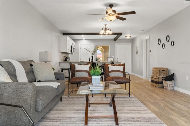 living room featuring ceiling fan with notable chandelier and light hardwood / wood-style floors