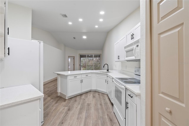 kitchen featuring lofted ceiling, sink, white cabinetry, kitchen peninsula, and white appliances