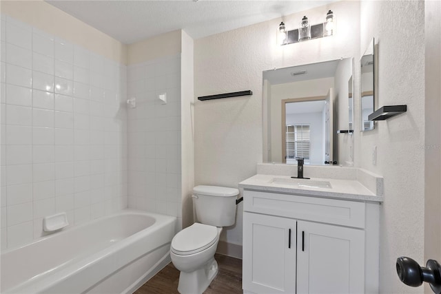 full bathroom featuring toilet, a textured ceiling, shower / bathtub combination, vanity, and hardwood / wood-style flooring