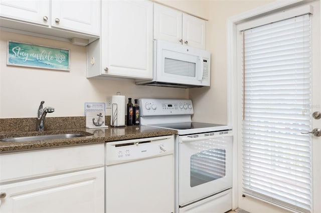 kitchen featuring sink, white appliances, white cabinets, and dark stone counters