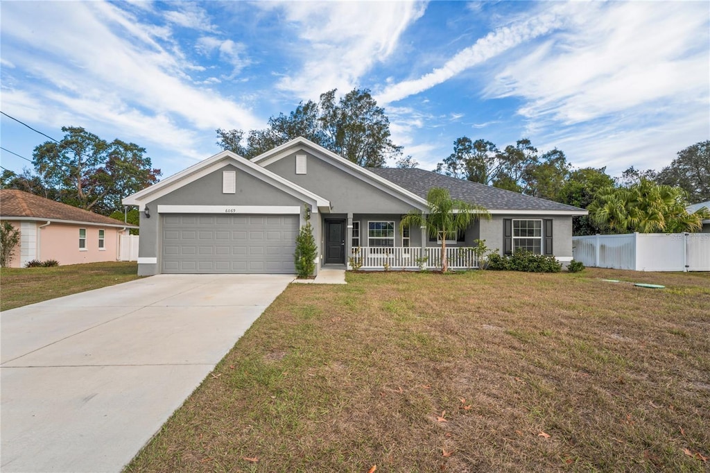 ranch-style home with a garage, covered porch, and a front lawn