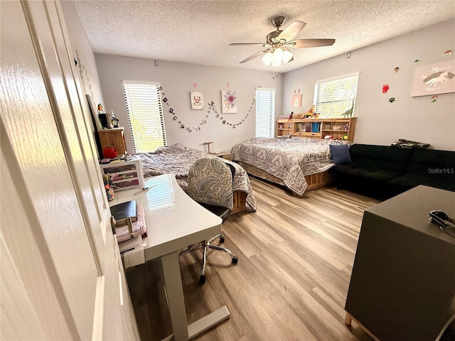 bedroom featuring light hardwood / wood-style floors, a textured ceiling, and ceiling fan