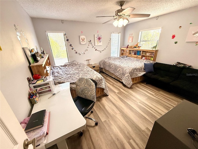 bedroom featuring light wood-type flooring, ceiling fan, a textured ceiling, and multiple windows