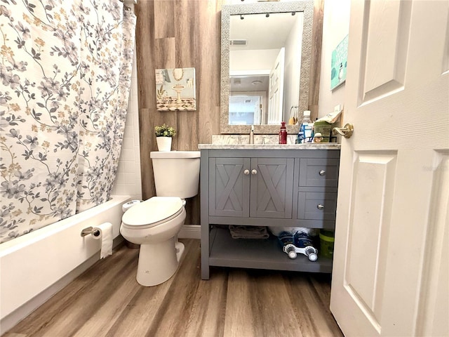 full bathroom with shower / bath combo with shower curtain, hardwood / wood-style floors, toilet, and vanity