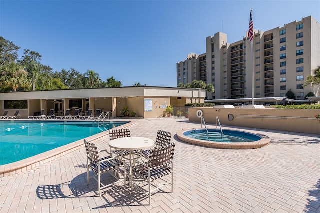 view of pool featuring a community hot tub and a patio