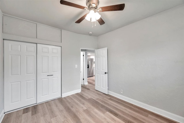 unfurnished bedroom with stainless steel fridge with ice dispenser, light hardwood / wood-style flooring, a closet, and ceiling fan