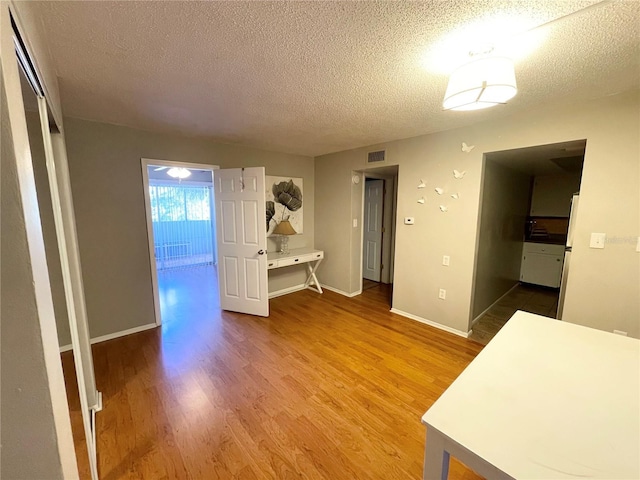 interior space featuring wood-type flooring, a closet, and a textured ceiling