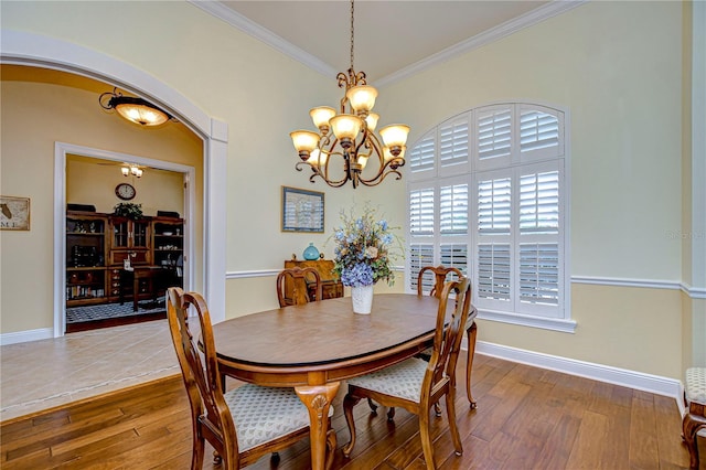 dining area with ornamental molding, hardwood / wood-style floors, and a notable chandelier