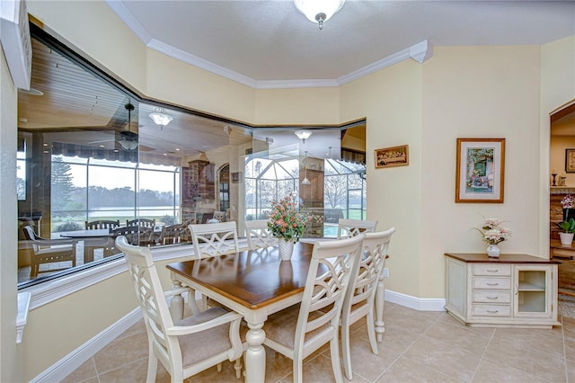 dining space featuring ceiling fan, ornamental molding, and light tile patterned floors