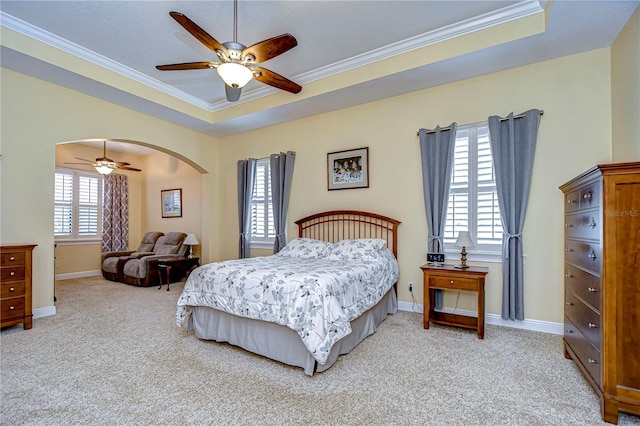 carpeted bedroom with crown molding, ceiling fan, and a tray ceiling