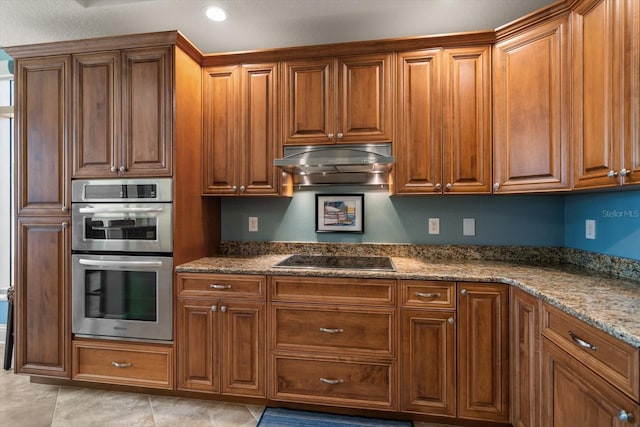 kitchen with stainless steel double oven, light tile patterned floors, black electric stovetop, and stone countertops