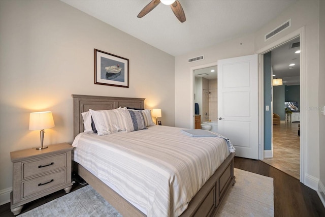 bedroom featuring ceiling fan, ensuite bathroom, and dark hardwood / wood-style floors