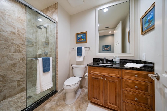 bathroom with toilet, vanity, tile patterned flooring, and a shower with door