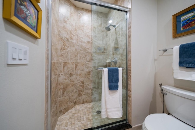 bathroom featuring toilet and an enclosed shower