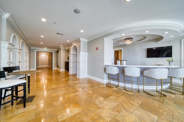 kitchen with ornamental molding and a textured ceiling