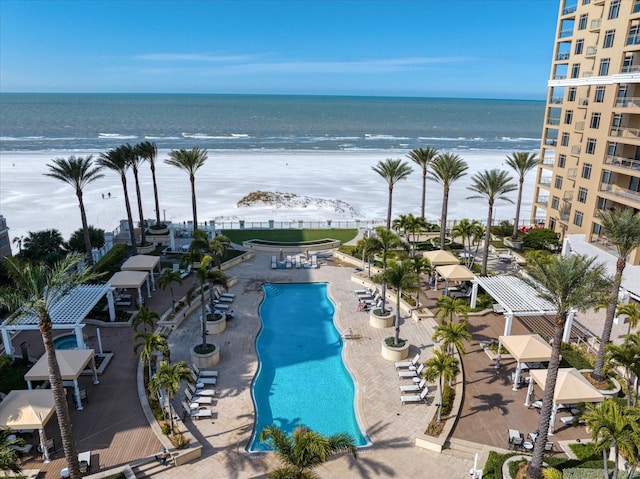 view of pool with a view of the beach, a water view, and a patio