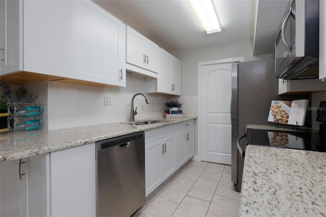 kitchen featuring appliances with stainless steel finishes, white cabinetry, decorative backsplash, sink, and light tile patterned floors