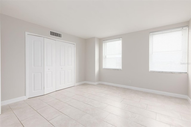 unfurnished bedroom featuring light tile patterned floors and a closet