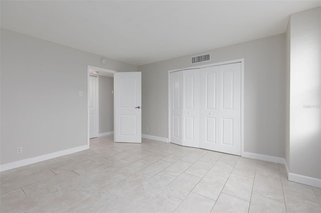 unfurnished bedroom with a closet and light tile patterned flooring