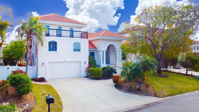 mediterranean / spanish home with a front yard, a garage, and a balcony