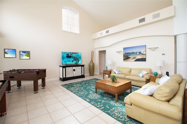 living room featuring light tile patterned flooring and a towering ceiling