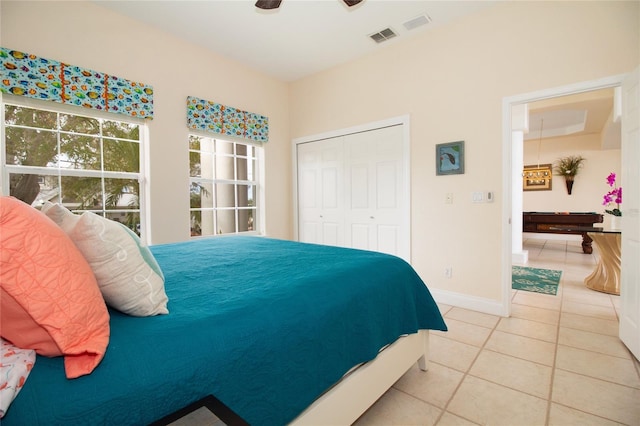 tiled bedroom with ceiling fan and a closet