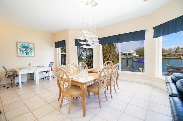 tiled dining room featuring a water view and an inviting chandelier