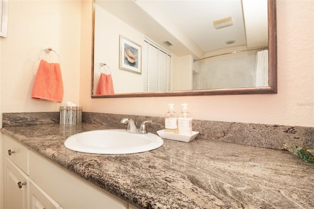 bathroom featuring vanity and a shower