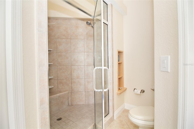 bathroom featuring a shower with shower door, toilet, and tile patterned flooring