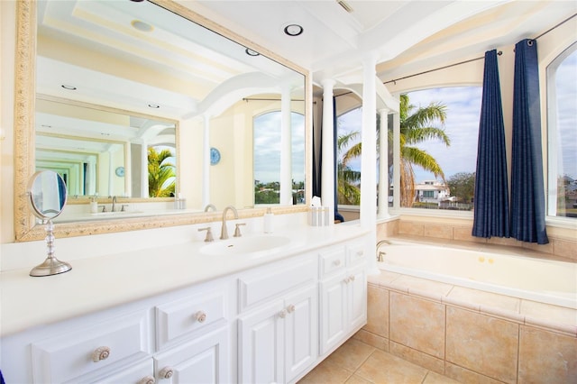 bathroom with tile patterned floors, tiled tub, and vanity