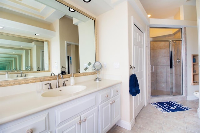 bathroom with toilet, vanity, a shower with door, and tile patterned floors