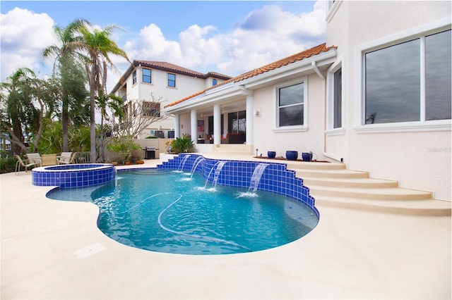 view of pool with an in ground hot tub, pool water feature, and a patio