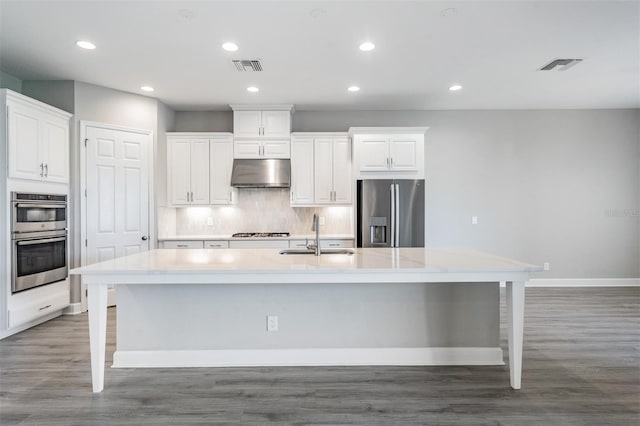 kitchen with sink, appliances with stainless steel finishes, dark hardwood / wood-style flooring, and a large island