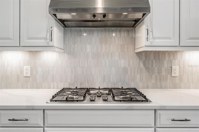 kitchen with white cabinetry, exhaust hood, decorative backsplash, and stainless steel gas cooktop