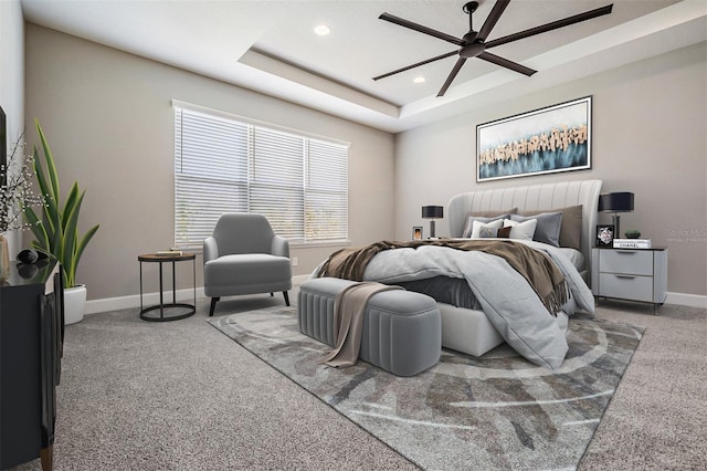 bedroom featuring ceiling fan, carpet, and a tray ceiling