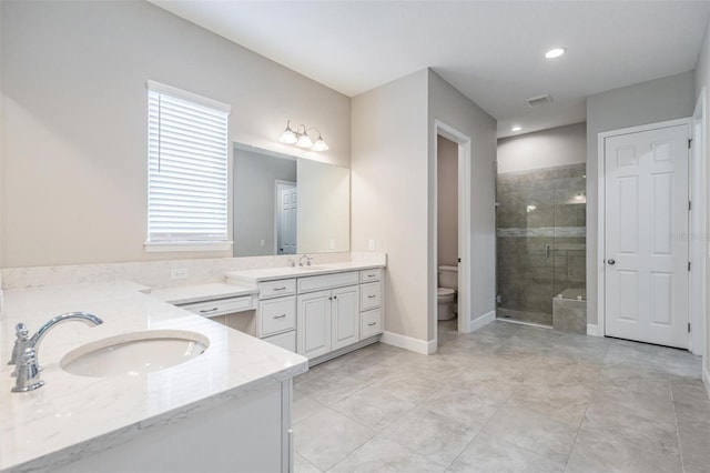 bathroom with toilet, vanity, and walk in shower