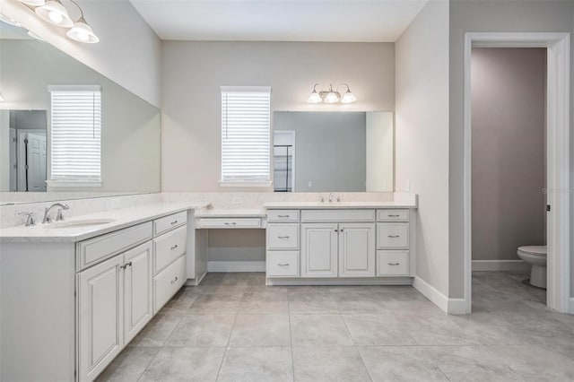 bathroom featuring plenty of natural light, toilet, tile patterned floors, and vanity