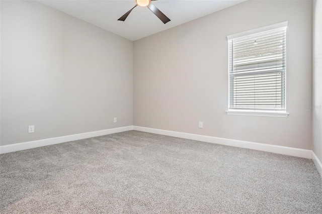 empty room with ceiling fan, a wealth of natural light, and carpet flooring