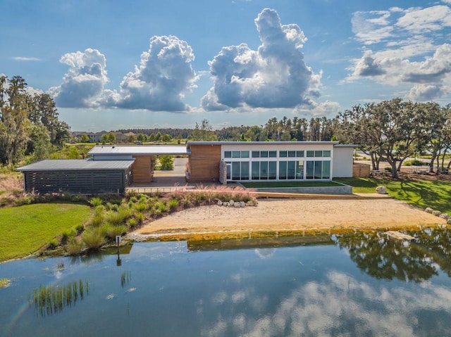 back of house featuring volleyball court and a water view