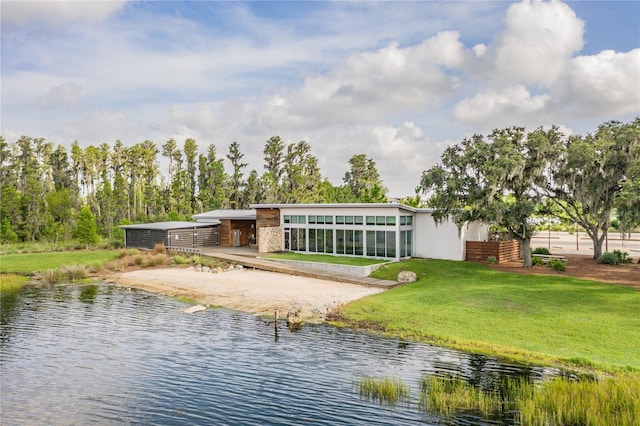 back of house featuring a yard and a water view