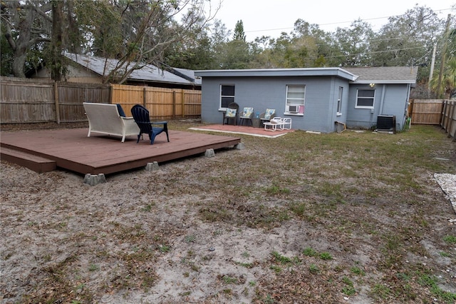 rear view of house with a wooden deck, cooling unit, and central air condition unit