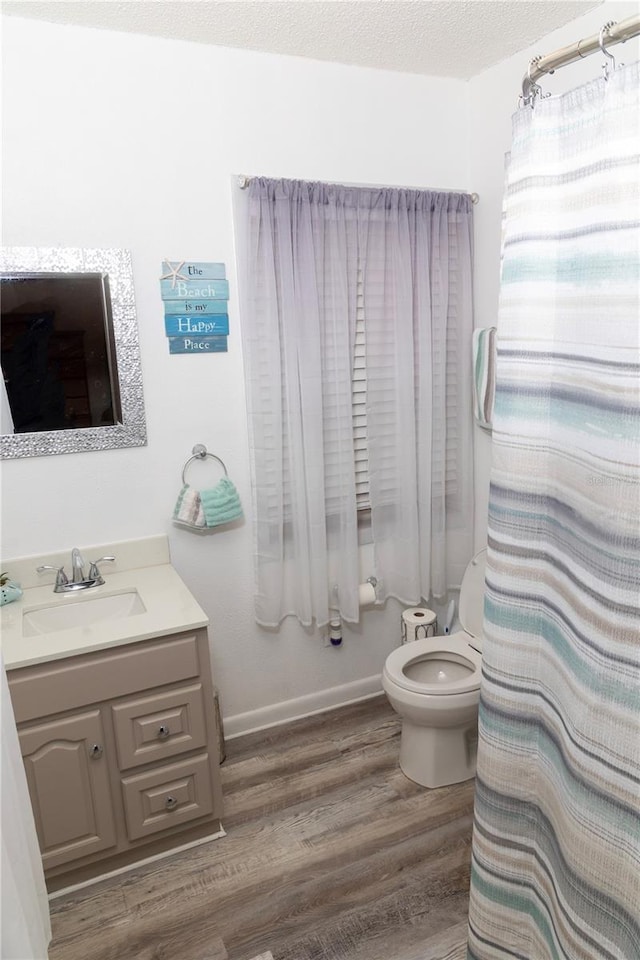 bathroom with toilet, vanity, hardwood / wood-style flooring, a textured ceiling, and a shower with shower curtain