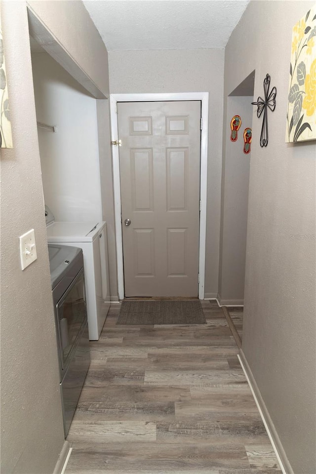 laundry room featuring washing machine and dryer and hardwood / wood-style flooring