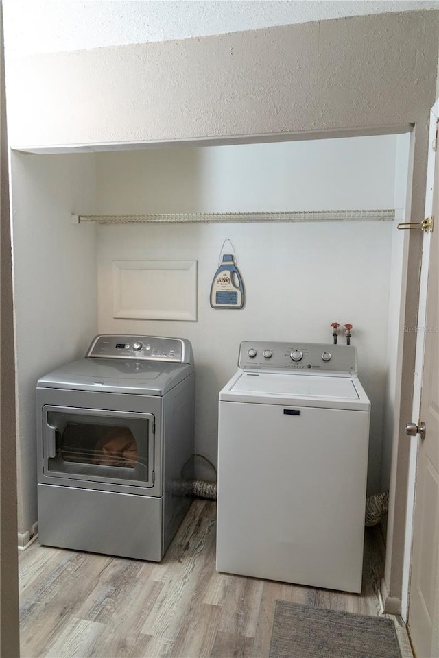 washroom with light wood-type flooring and separate washer and dryer