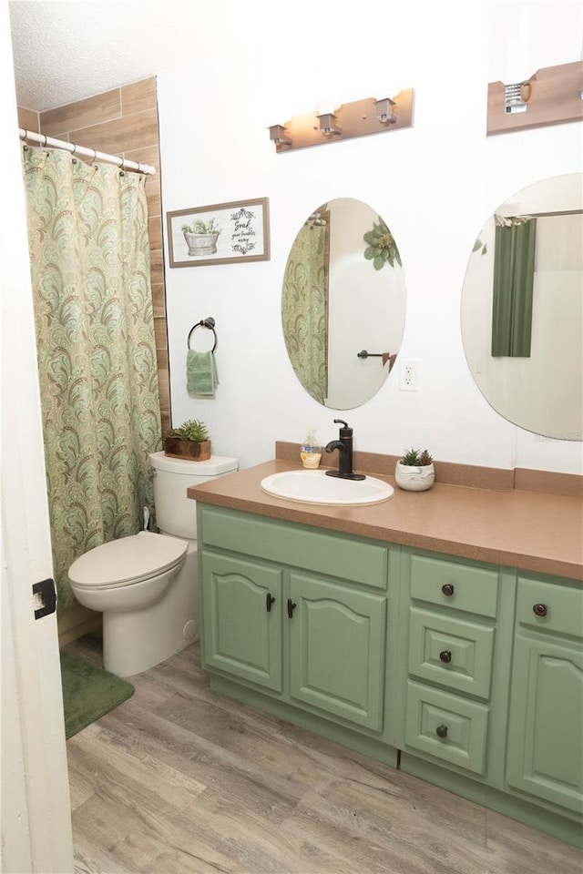 bathroom featuring hardwood / wood-style flooring, toilet, and vanity