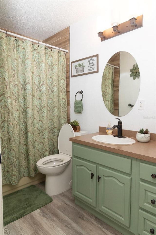 bathroom featuring hardwood / wood-style flooring, a textured ceiling, toilet, and vanity