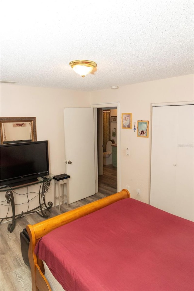 bedroom featuring a textured ceiling, light hardwood / wood-style flooring, and billiards