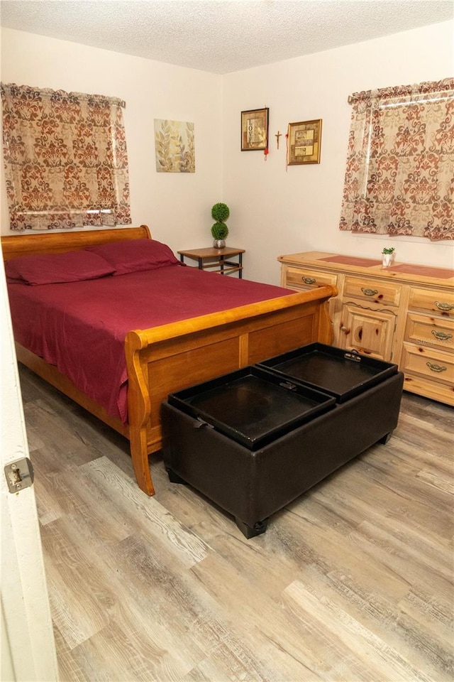 bedroom with wood-type flooring and a textured ceiling