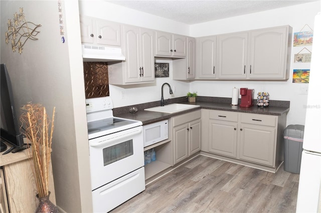 kitchen featuring gray cabinetry, white appliances, light wood-type flooring, a textured ceiling, and sink