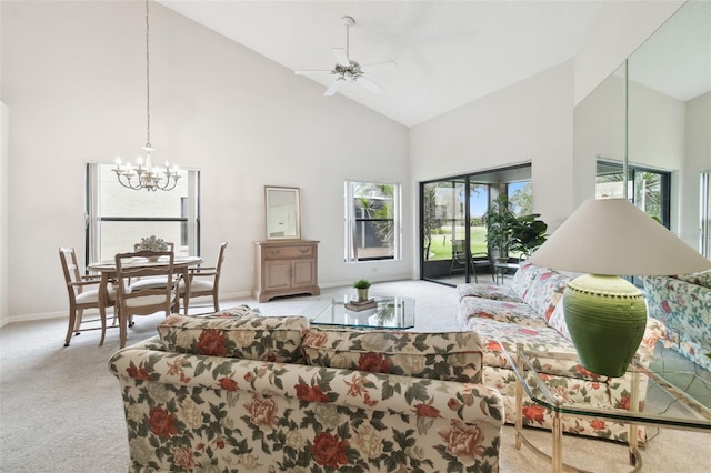 carpeted living room featuring high vaulted ceiling, ceiling fan with notable chandelier, and a healthy amount of sunlight